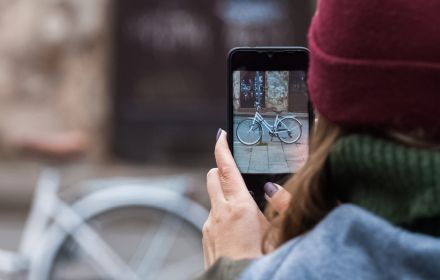 lady taking picture of bike with her mobile phone
