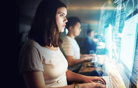 Young woman looking at data on computer screen