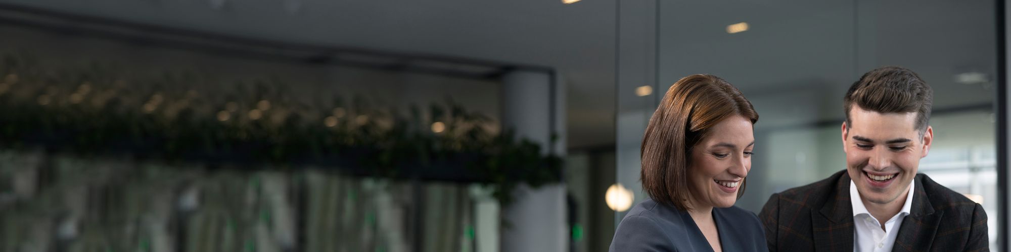 Sævar og Callista ræða saman gangandi á svölum Borgartúns 27 með glerbyggingar í Borgartúni fyrir aftan sig