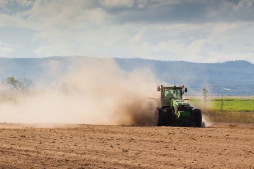 A tractor plowing dry farmland