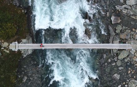 Aerial-view of a person crossing a river through bridge