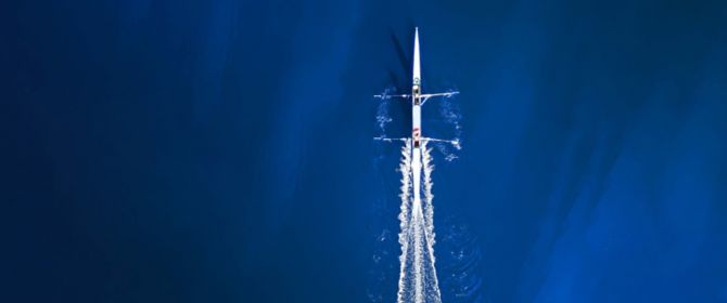 Aerial view of a rowing boat surrounded by classic blue water