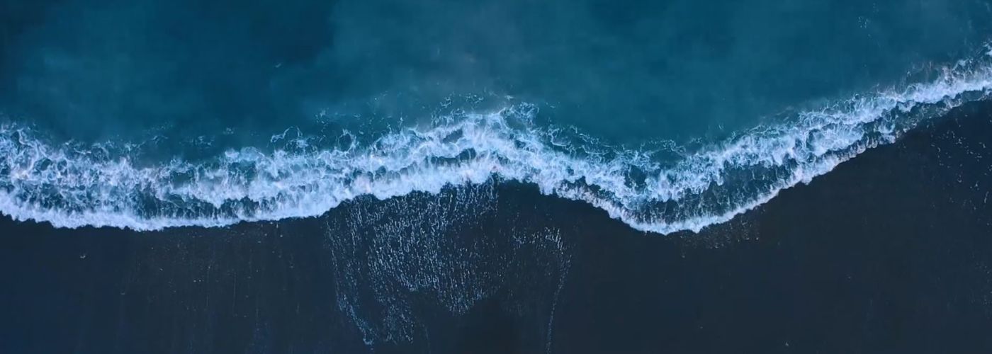 Aerial view of sea waves reaching shore
