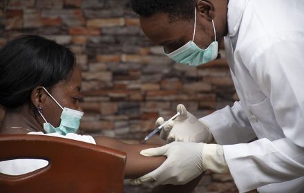 African doctor injecting an african woman with a vaccine