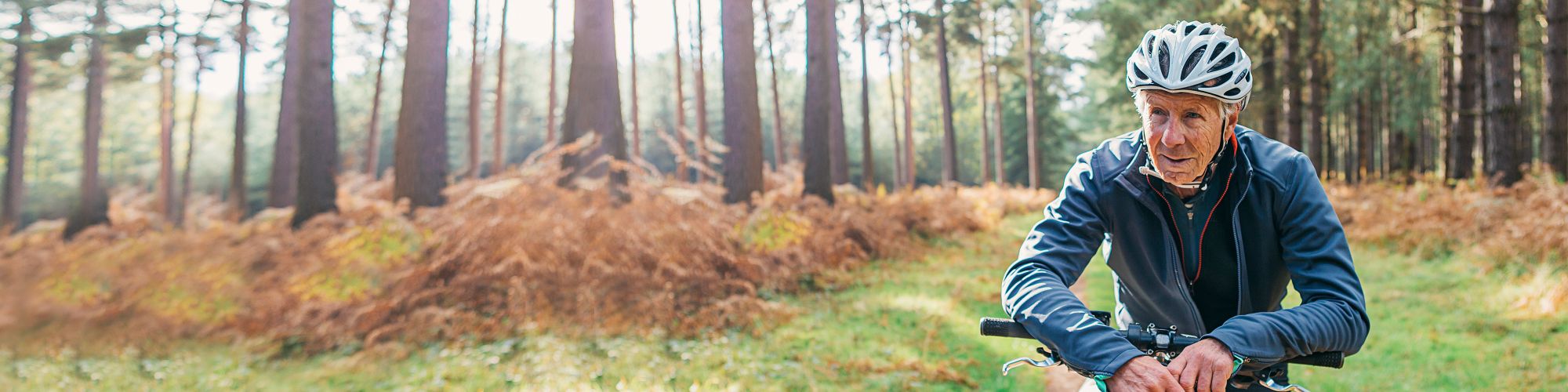 Senior man on bicycle in forest