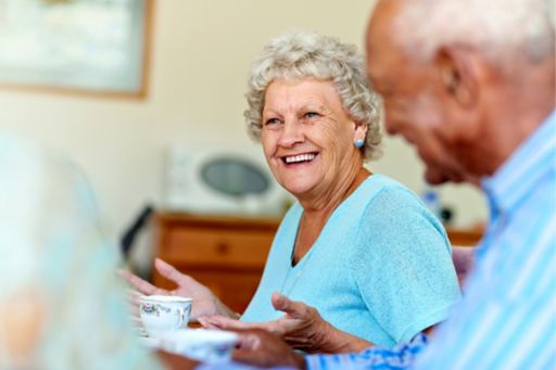 Senior woman spending leisure time with friends in aged care setting