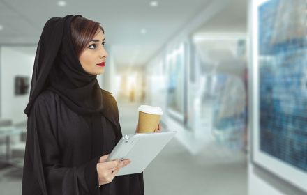 Arabic woman holding tablet and coffee