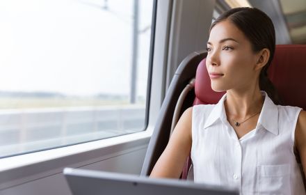 A woman works on a laptop while travelling by train 