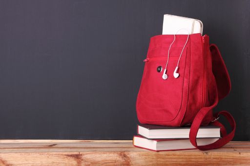 Digital tablet in a red backpack in front of blackboard
