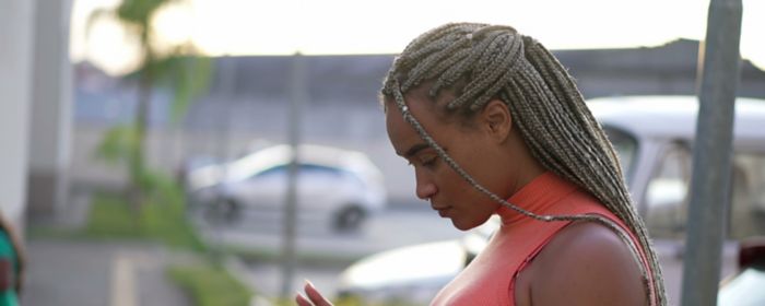 A black woman looks at her phone