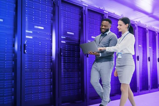 Man and woman walking next to a server room