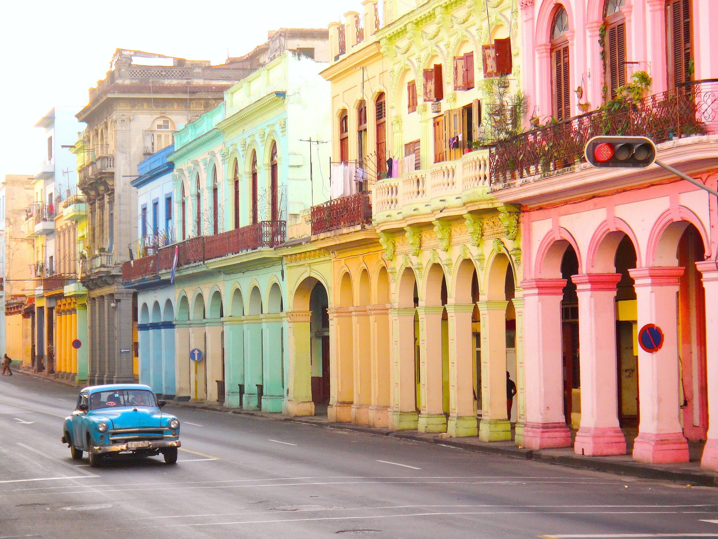 Blue car infront of colourful buildings