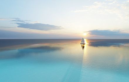 Boat in the middle of ocean at sunset