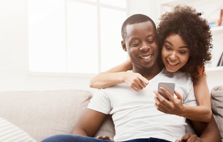 Boy and girl watching something on mobile and smiling