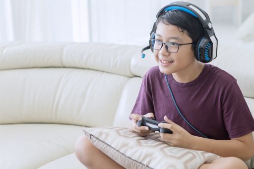 Boy playing video game sitting on couch