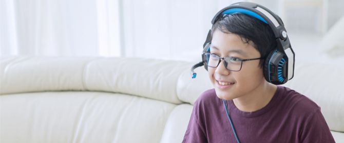 Boy playing video game sitting on couch