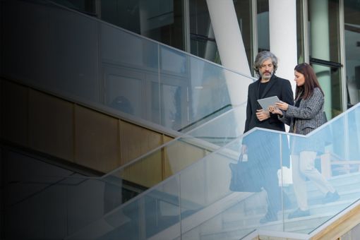 Business man and woman discussing something while walking downstairs