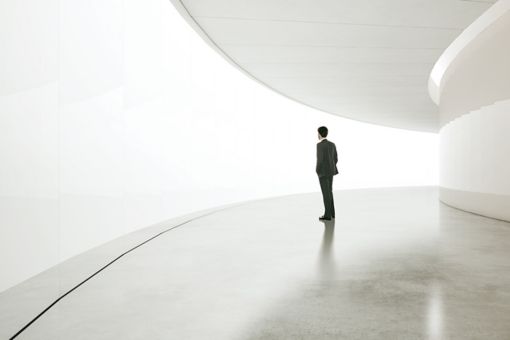Business man standing in a curved hallway