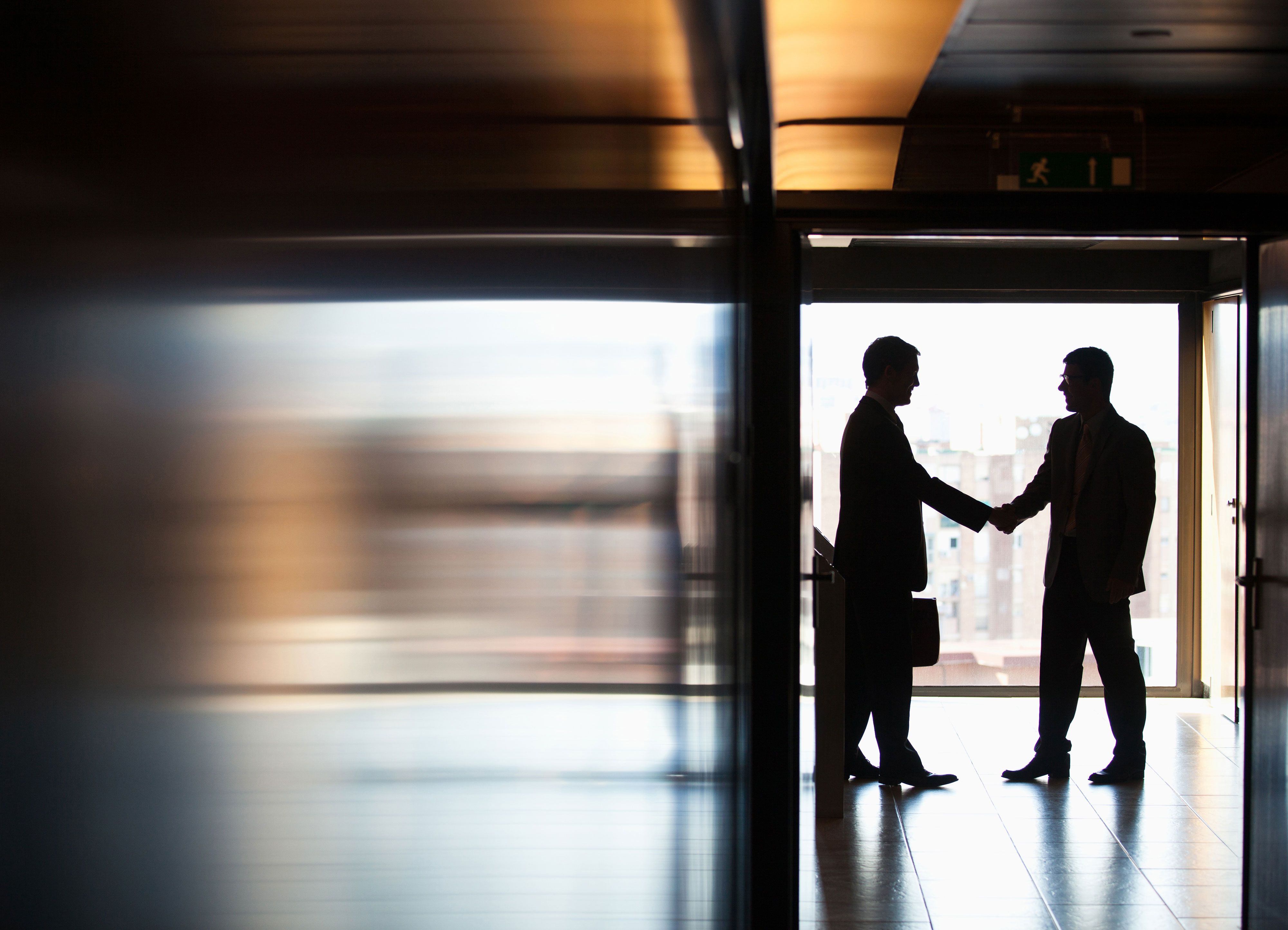 businessmen shaking hands in a corridor