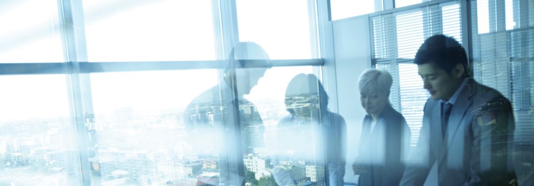 businesspersons in a boardroom with shiny windows