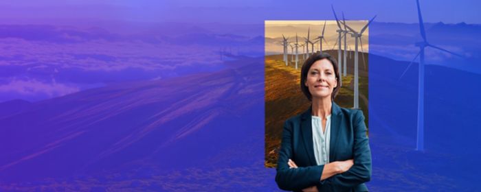 Businesswoman in front of mountains and wind turbines