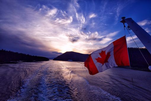 Canadian flag blowing in the wind over seas