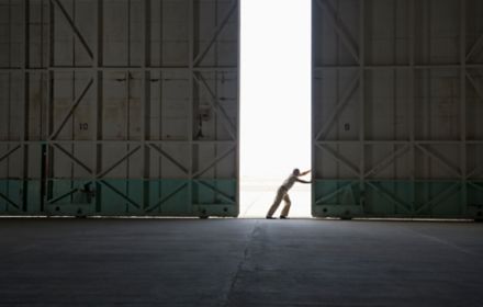 Caucasian worker opening large warehouse doors