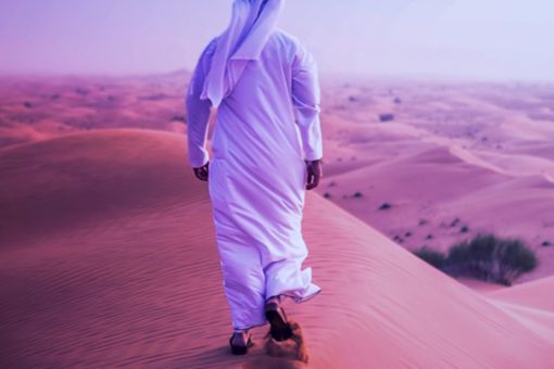 An Arab person walking in the desert