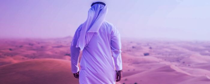 An Arab person walking in the desert
