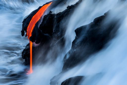 Changing state of distant lava flowing into wild ocean
