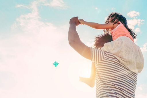 Child on father's shoulders in Sun