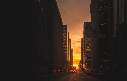 City road between buildings at sunrise