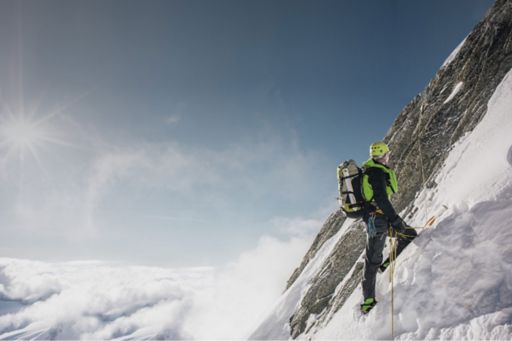 homem escalando montanha com gelo