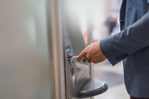 Close-up of businessman withdrawing money at an ATM 