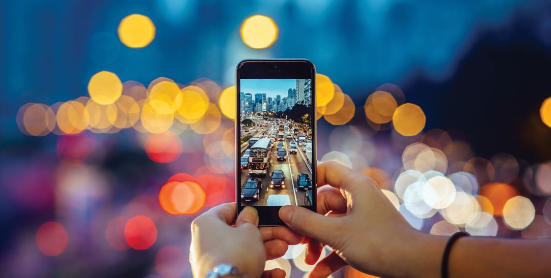 close-up of hands taking picture of traffic