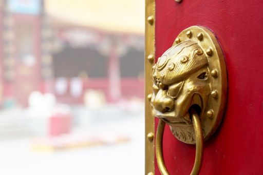 Red door with Asian handle ajar