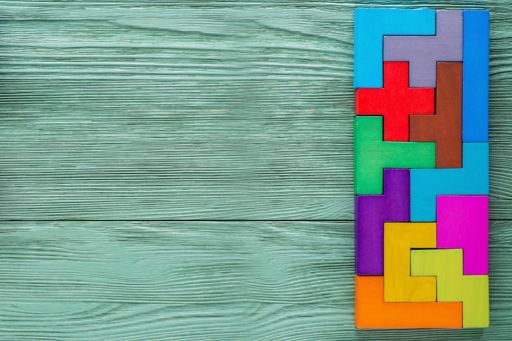 Colourful tetris blocks on a green wooden background