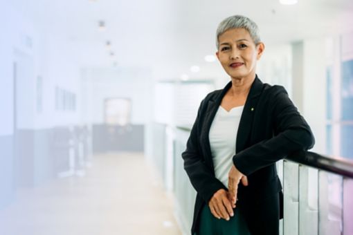 Confident middle-aged Asian business woman standing in a modern workplace