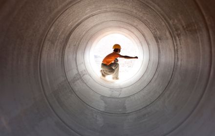 Construction worker inspecting water pipeline
