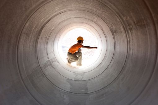 Construction worker inspecting water pipeline