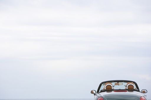 Convertible stands by the sea with a wide horizon