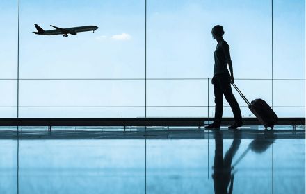 Silhouette of lady with luggage at an airport