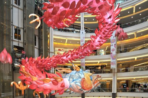 a dragon flying in front of buildings for lunar new year
