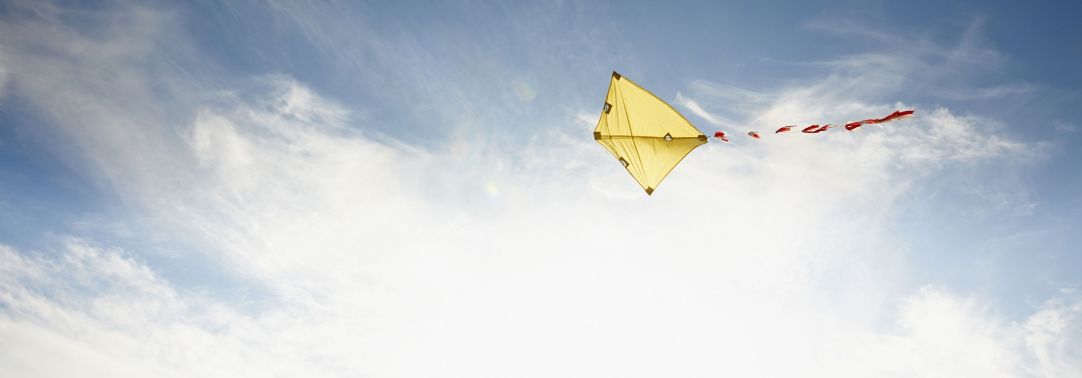 yellow kite flying in sky