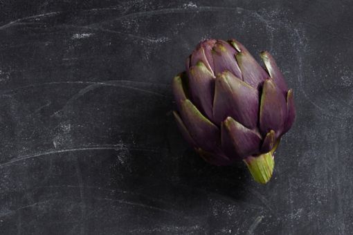 Picture of an artichoke on a marbled black background