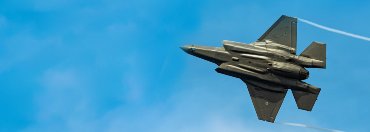 Dark grey fighter plane flying in the sky