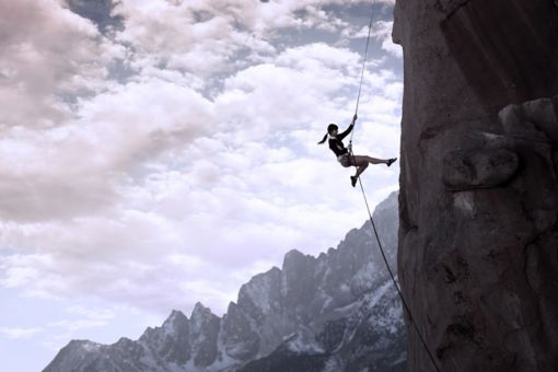 Person klatrer op ad bjerg