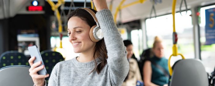 Person lytter til podcast i bus