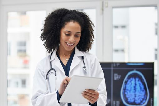 doctor-smiling-looking-at-tablet