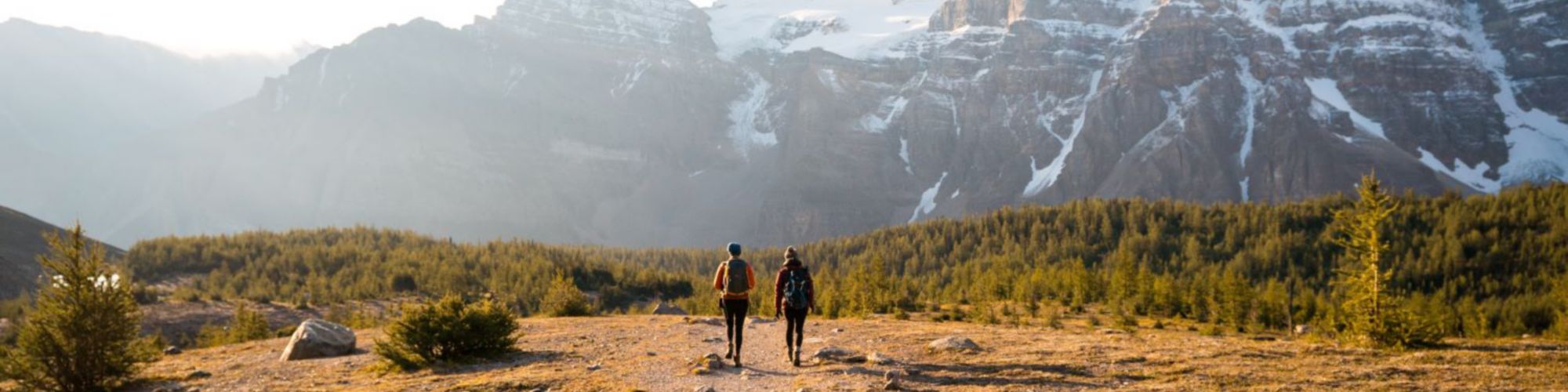 Dos personas caminando un sendero hacia la montaña